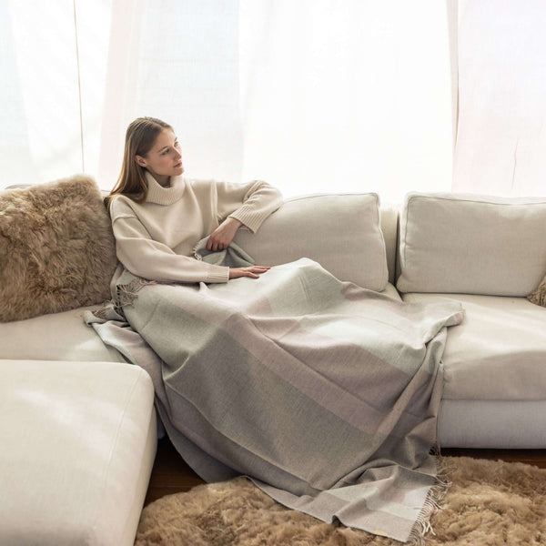 Frau auf dem Sofa mit Plaid BORREA