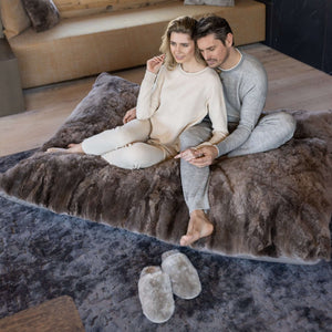 Paar sitzt auf Lounger REY und daneben liegen Hausschuhe PATO