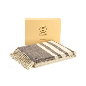 Alpaka Boucle Wolldecke MULLIDA sorgfältig gefaltet auf weißem Untergrund inklusive zugehöriger Verpackung