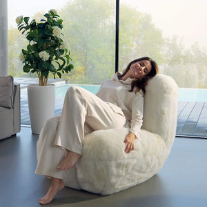 Frau sitzt auf Toe Chair Sessel DEDO im Wohnzimmer 