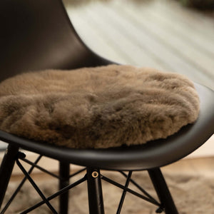 Rundes Sitzkissen ASIENTO aus Alpaka liegt auf einem Esszimmerstuhl